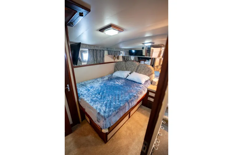  Yacht Photos Pics Cozy bedroom interior of 1984 Hatteras 52 Convertible yacht with blue bedding.