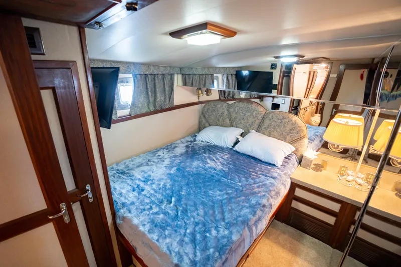  Yacht Photos Pics Luxurious bedroom interior of 1984 Hatteras 52 Convertible yacht with plush bedding and elegant decor.
