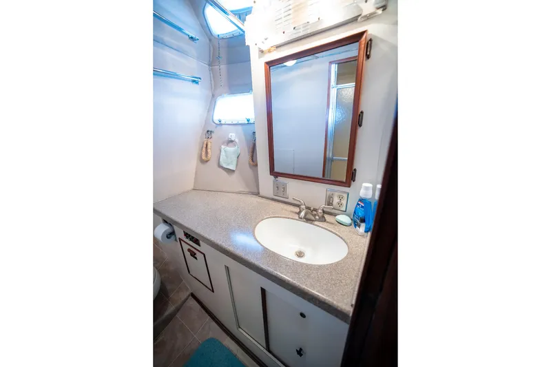  Yacht Photos Pics 1984 Hatteras 52 Convertible yacht bathroom with sink, mirror, and toiletries.