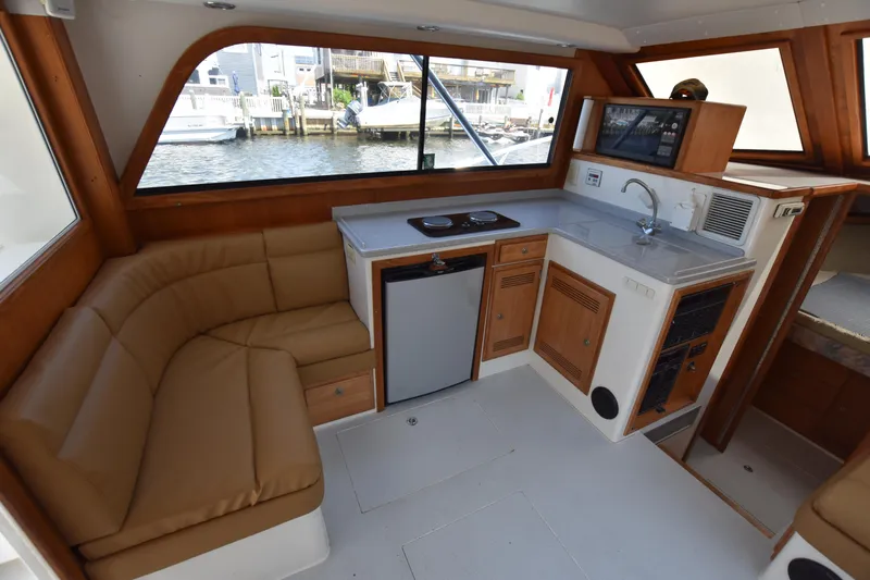  Yacht Photos Pics Interior of a 1994 Cabo 35 Flybridge Sportfisher with kitchenette and seating area.