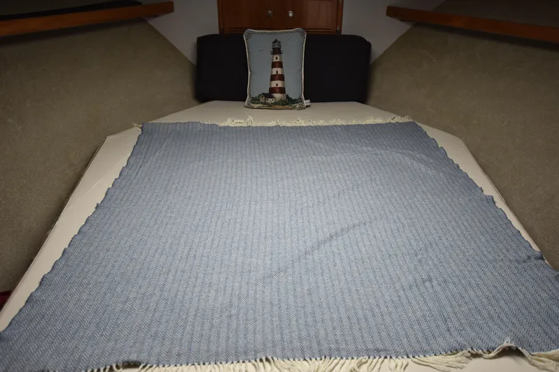  Yacht Photos Pics Cabo 35 Flybridge Sportfisher 1994 cabin bed with blue blanket and lighthouse pillow.