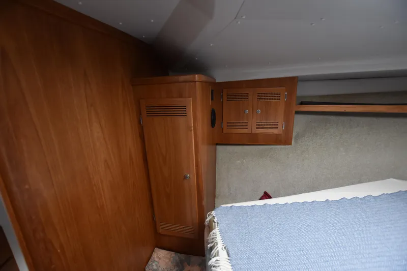  Yacht Photos Pics 1994 Cabo 35 Flybridge Sportfisher cabin interior with wooden cabinets and bed.