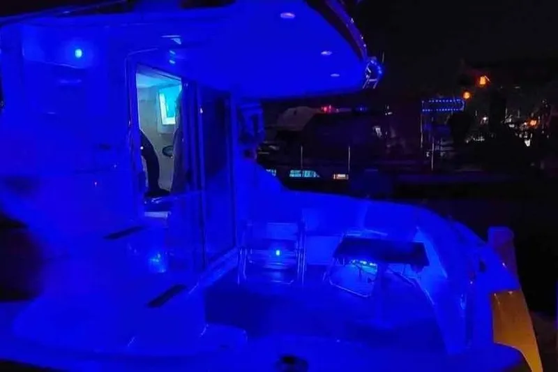  Yacht Photos Pics 1997 Sea Ray 400 Sedan Bridge yacht illuminated with blue LED lights at night.