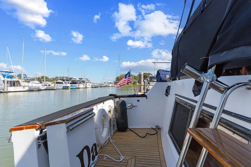 One Moor Day Yacht Photos Pics 1993 Ocean Alexander 440 yacht docked at marina, featuring American flag and clear blue sky.