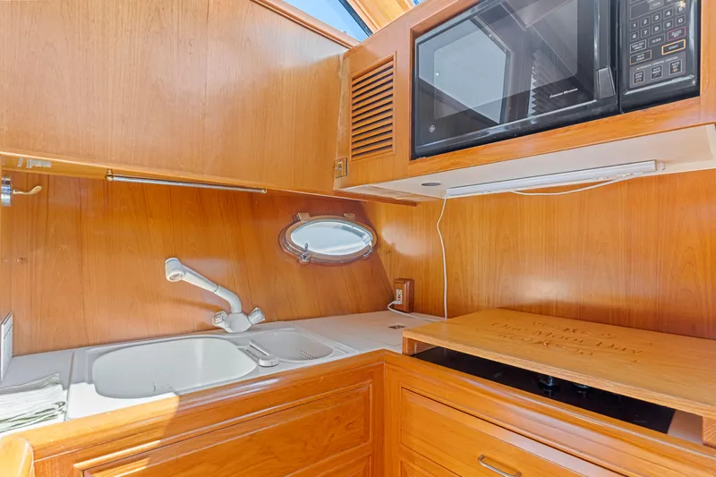 One Moor Day Yacht Photos Pics 1993 Ocean Alexander 440 yacht kitchen with wood cabinetry, sink, and microwave.