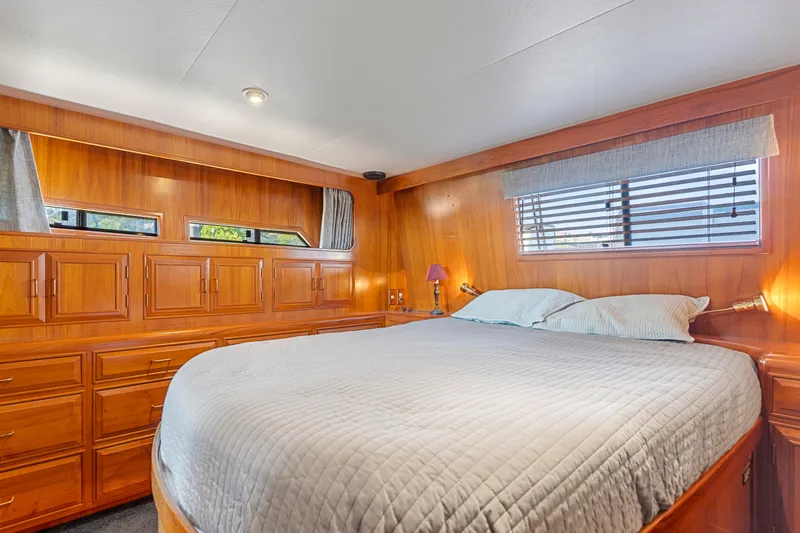 One Moor Day Yacht Photos Pics Luxurious 1993 Ocean Alexander 440 yacht bedroom with wood paneling and cozy bedding.