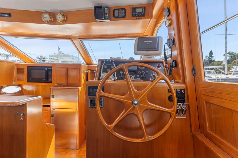 One Moor Day Yacht Photos Pics Interior helm of 1993 Ocean Alexander 440 yacht with wooden steering wheel and navigation equipment.
