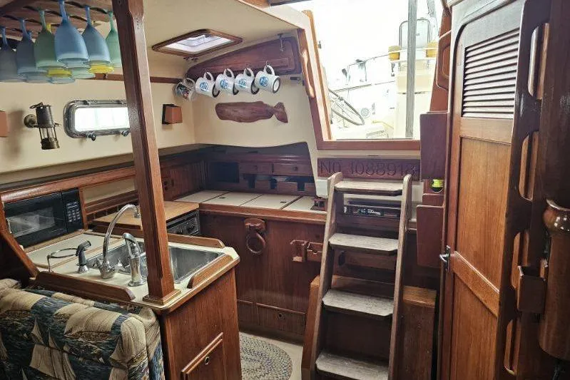 Water Dance Yacht Photos Pics Interior of 1999 Island Packet 350 sailboat with wooden cabinetry and kitchen amenities.