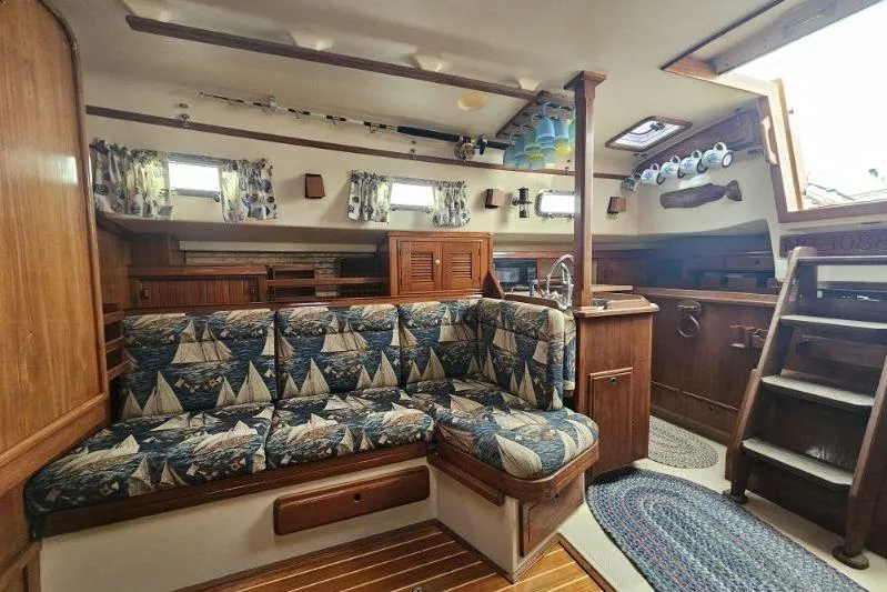 Water Dance Yacht Photos Pics Interior of 1999 Island Packet 350 sailboat with nautical-themed upholstery and wooden finishes.
