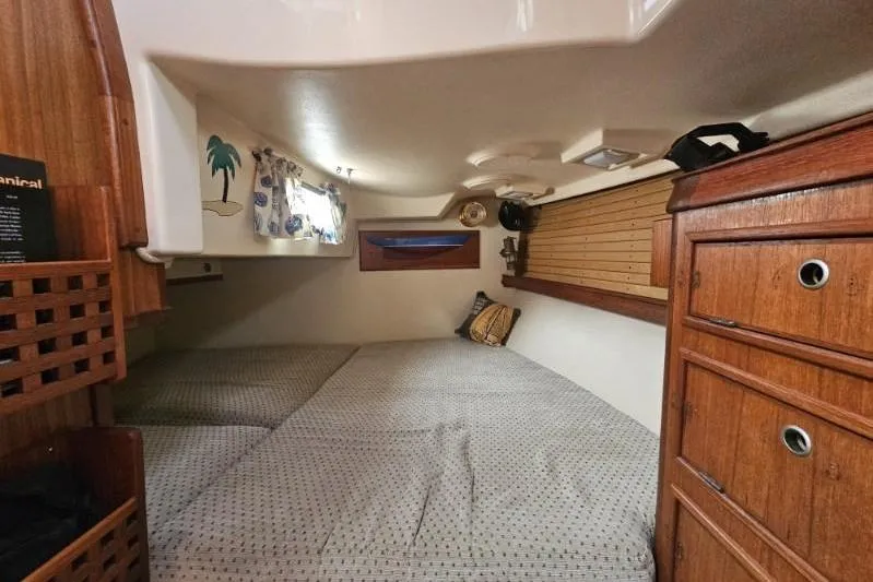 Water Dance Yacht Photos Pics 1999 Island Packet 350 cabin interior with cozy bed and wooden storage.