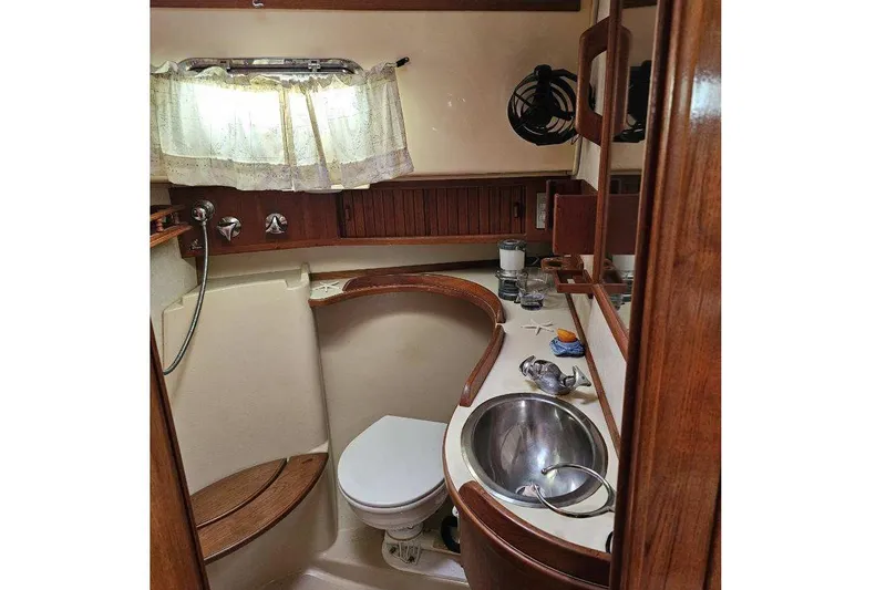 Water Dance Yacht Photos Pics 1999 Island Packet 350 yacht bathroom with sink, toilet, and wooden accents.
