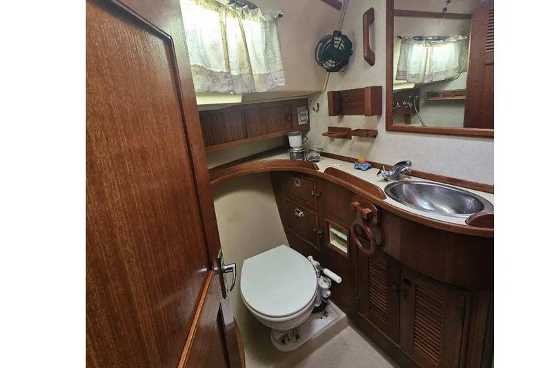 Water Dance Yacht Photos Pics 1999 Island Packet 350 yacht bathroom with wooden cabinetry and stainless steel sink.