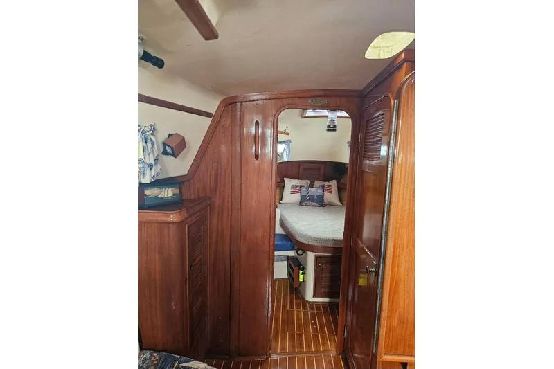 Water Dance Yacht Photos Pics Interior of 1999 Island Packet 350 sailboat, featuring cozy wooden cabin and bed.