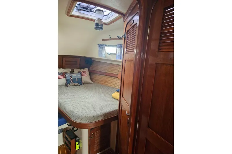 Water Dance Yacht Photos Pics Cozy cabin interior of 1999 Island Packet 350 sailboat with wooden finishes and bedding.