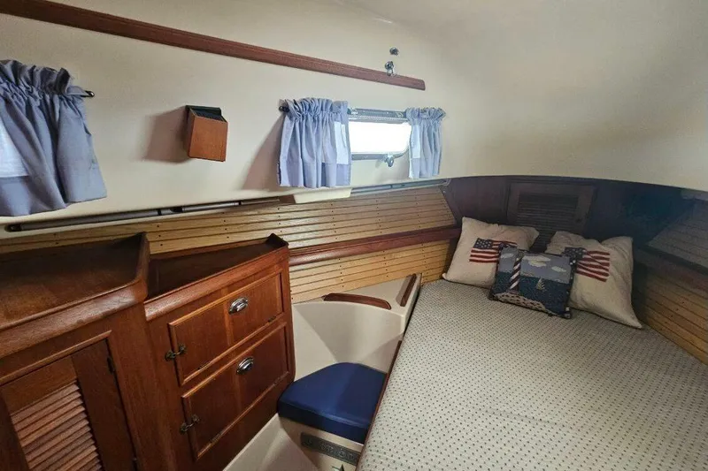 Water Dance Yacht Photos Pics Cozy cabin interior of 1999 Island Packet 350 sailboat with wooden cabinetry and nautical-themed pillows.