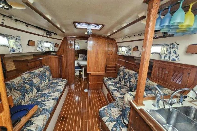Water Dance Yacht Photos Pics Interior of 1999 Island Packet 350 sailboat with wood finish and patterned seating.