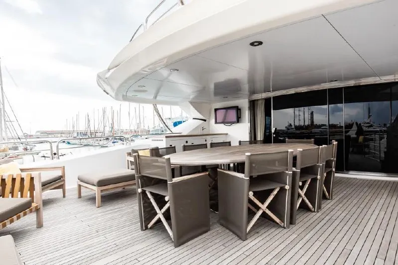 Yacht Photos Pics Outdoor dining area on 2014 Sunseeker 40 Metre Yacht, featuring elegant seating and marina view.