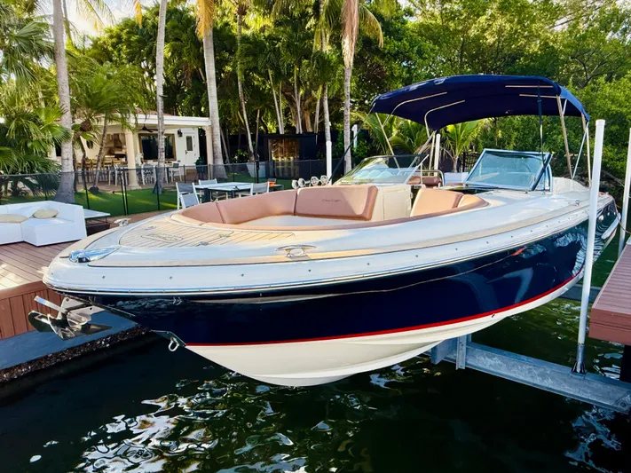  Yacht Photos Pics 2015 Chris-Craft Launch 32 boat docked near a tropical setting with lush greenery.