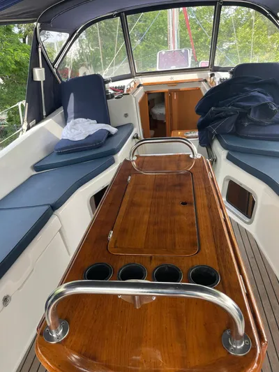 Kindred Spirit Yacht Photos Pics 2008 Jeanneau Sun Odyssey 45 DS cockpit with wooden table and cushioned seating.