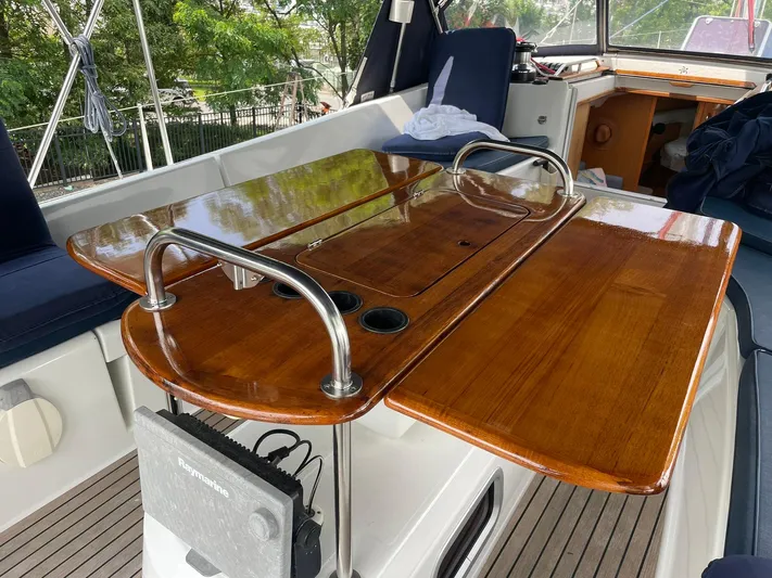 Kindred Spirit Yacht Photos Pics Cockpit of 2008 Jeanneau Sun Odyssey 45 DS with polished wooden table and seating.