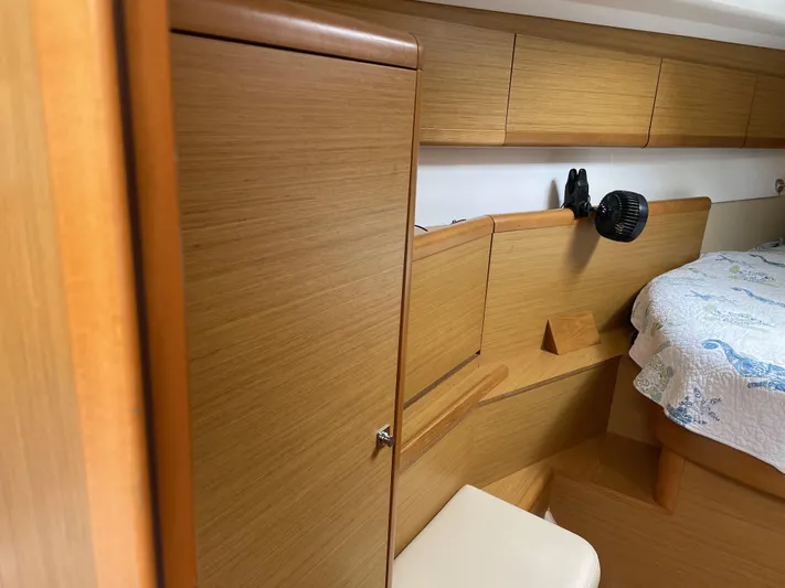Kindred Spirit Yacht Photos Pics Interior cabin of 2008 Jeanneau Sun Odyssey 45 DS yacht, featuring wood paneling and cozy bedding.