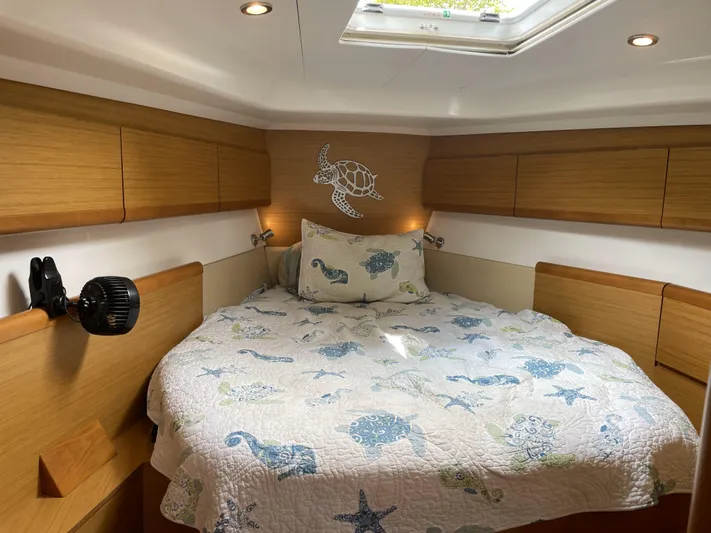 Kindred Spirit Yacht Photos Pics Cozy cabin interior of 2008 Jeanneau Sun Odyssey 45 DS with nautical-themed bedding.