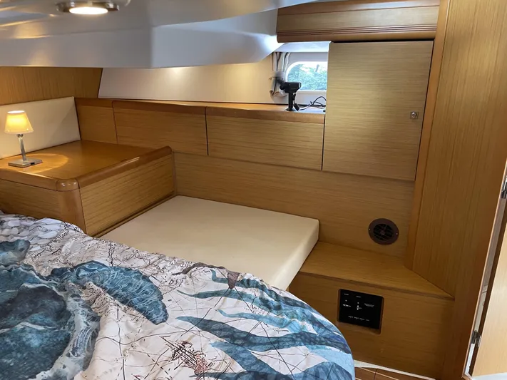 Kindred Spirit Yacht Photos Pics Interior cabin of 2008 Jeanneau Sun Odyssey 45 DS with wooden finish and cozy bedding.