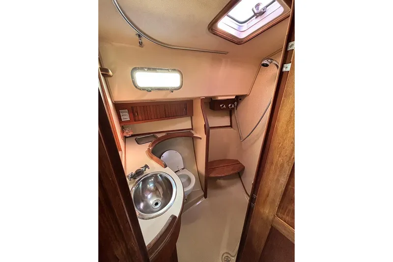 Butternut Yacht Photos Pics 1995 Island Packet 37 sailboat bathroom with sink, toilet, and wooden accents.