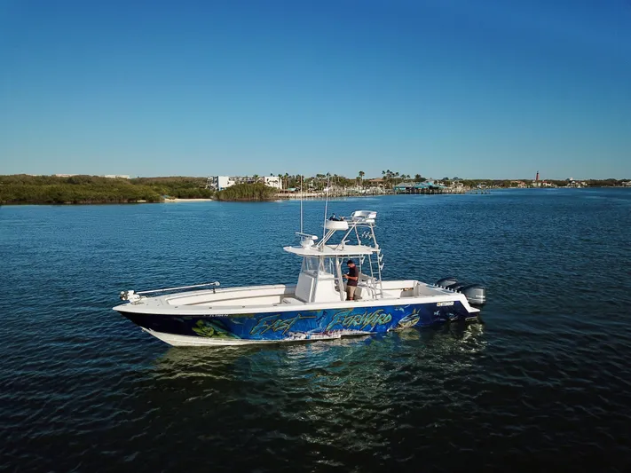 Fast Forward Yacht Photos Pics 2010 Contender 39 ST boat on calm water with scenic background.
