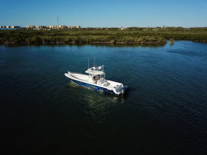 Fast Forward Yacht Photos Pics 2010 Contender 39 ST boat cruising on a calm river under clear blue skies.