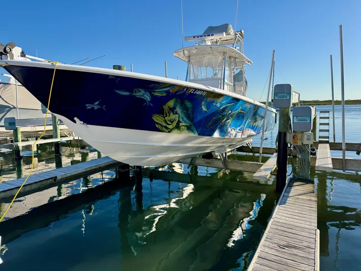 Fast Forward Yacht Photos Pics 2010 Contender 39 ST boat with vibrant marine artwork docked at a marina.