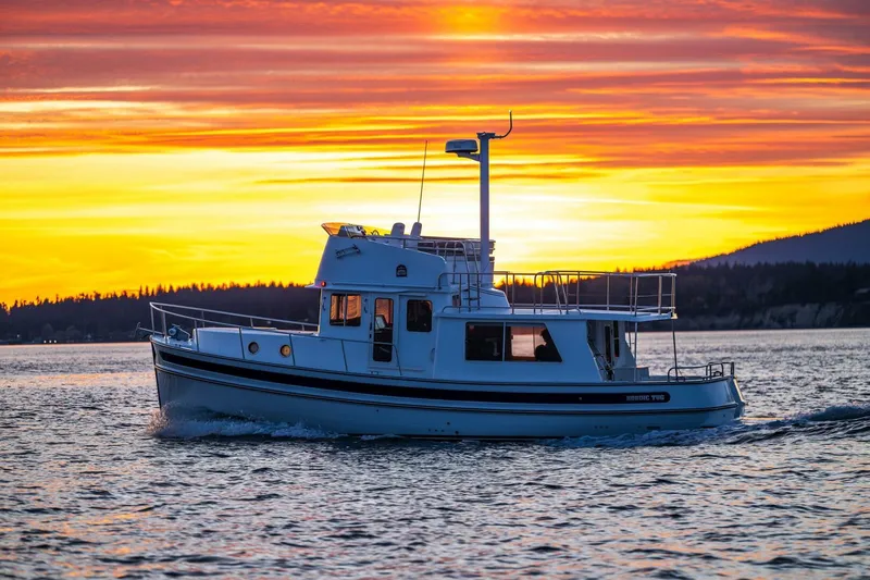 New Boat Hull #12 Yacht Photos Pics 2024 Nordic Tug 40 cruising at sunset on serene waters.