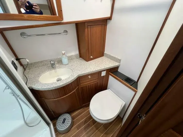 New Boat Hull #12 Yacht Photos Pics 2024 Nordic Tug 40 bathroom with wood cabinetry, granite countertop, and modern fixtures.