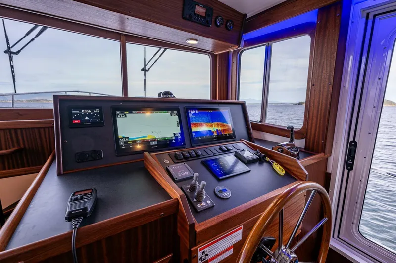 New Boat Hull #12 Yacht Photos Pics 2024 Nordic Tug 40 helm with modern navigation equipment and ocean view.