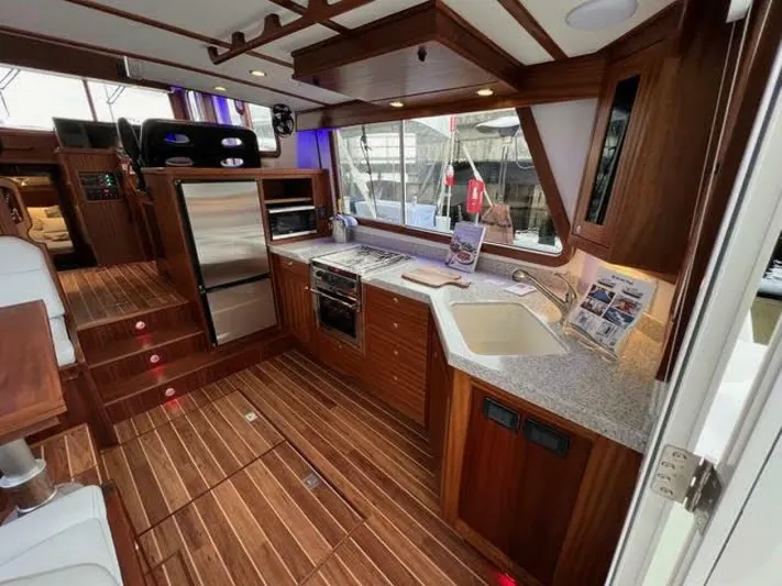 New Boat Hull #12 Yacht Photos Pics Luxurious 2024 Nordic Tug 40 interior with modern kitchen and wooden flooring.