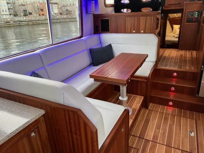 New Boat Hull #12 Yacht Photos Pics Luxurious interior of 2024 Nordic Tug 40 with wood accents and comfortable seating.