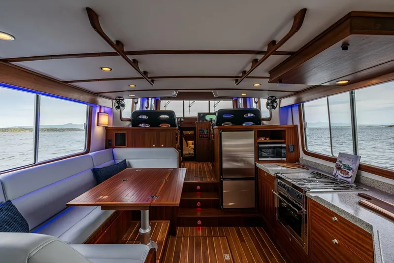 New Boat Hull #12 Yacht Photos Pics Luxurious interior of 2024 Nordic Tug 40 yacht with modern kitchen and dining area.