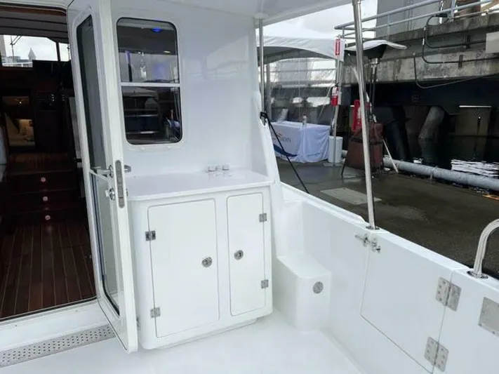 New Boat Hull #12 Yacht Photos Pics 2024 Nordic Tug 40 boat interior with white cabinetry and wooden flooring.