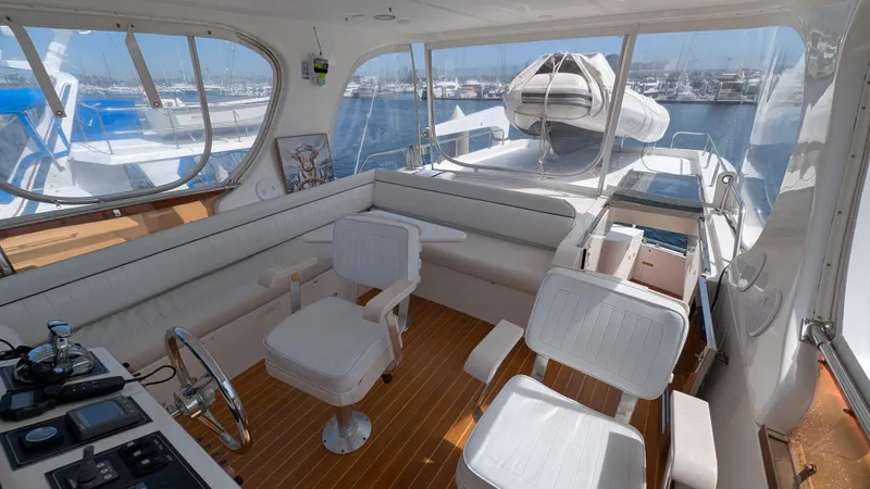 Odeesea Yacht Photos Pics 2004 Johnson Motor Yacht interior with white seating and helm, docked at marina.