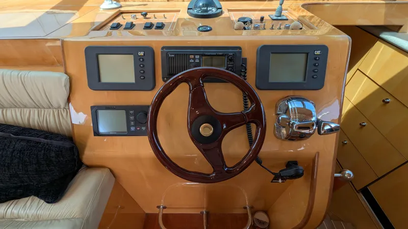 Odeesea Yacht Photos Pics 2004 Johnson Motor Yacht helm with wooden steering wheel and navigation controls.