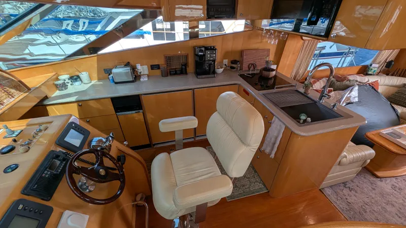 Odeesea Yacht Photos Pics Luxurious 2004 Johnson Motor Yacht interior with helm, kitchen, and seating area.