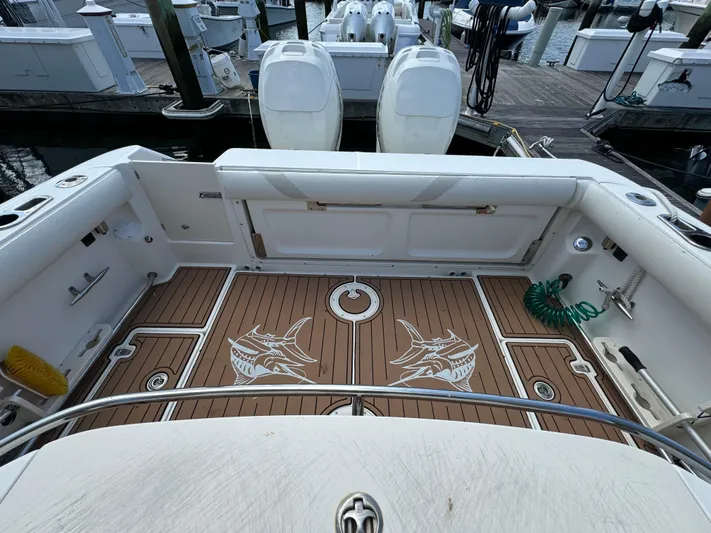 No Name Yacht Photos Pics 2006 Boston Whaler 32 Outrage Cuddy boat deck with shark design, docked at marina.