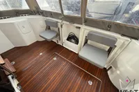 2017 Beneteau Swift Trawler 30 interior with wooden flooring and foldable seating.