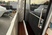 2017 Beneteau Swift Trawler 30, side deck view with wooden flooring and glass door.
