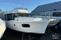 2017 Beneteau Swift Trawler 30 in storage, white exterior, docked at a marina.