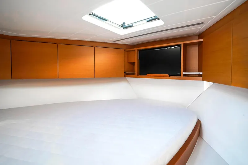 One More Yacht Photos Pics Interior of 2018 Bertram 35 Flybridge Sportfish with bed, TV, and wooden cabinets.