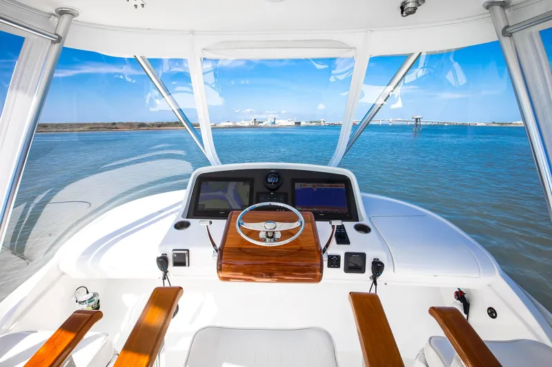 One More Yacht Photos Pics 2018 Bertram 35 Flybridge Sportfish helm with ocean view, featuring modern navigation equipment.