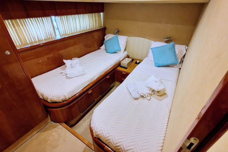  Yacht Photos Pics Twin cabin interior of 2000 Ferretti Yachts 72 with cozy beds and blue pillows.