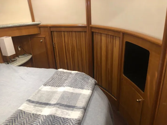  Yacht Photos Pics Interior of 2002 Carver 450 Voyager Pilothouse with wood paneling and cozy bedding.