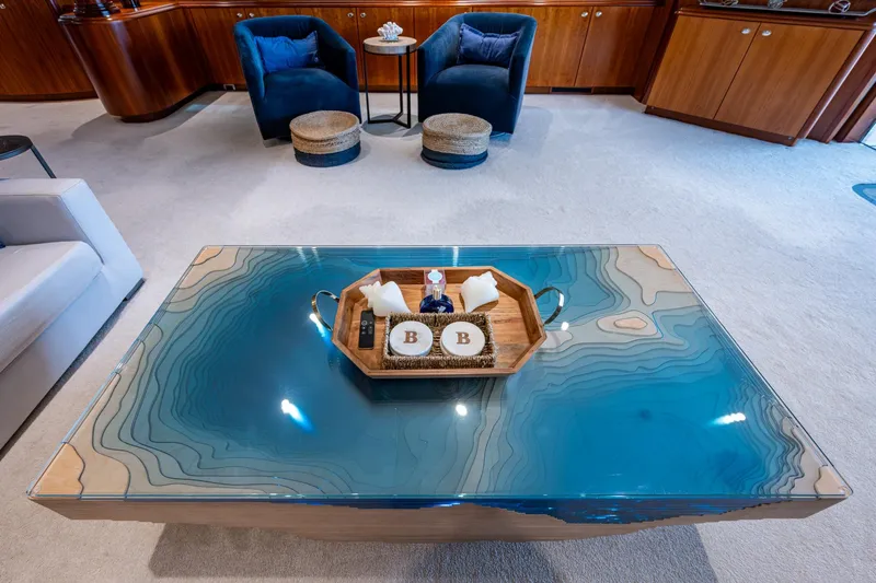 Lila Cuy Yacht Photos Pics Luxurious yacht interior with elegant blue table, wooden accents, and plush seating, Westport 112, 2006.